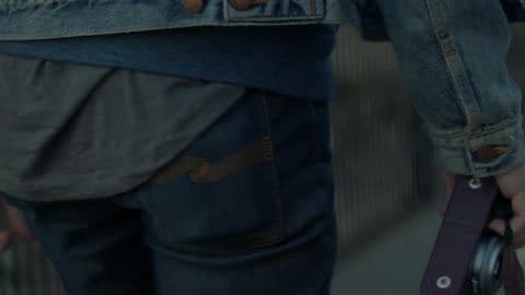 A Man Carries a Camera Down the Street