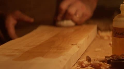 A Man Is Polishing Some Wood with a Cloth