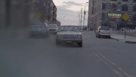 A Brown Car Driving Down The Street