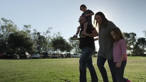 A Family Walking In The Grass