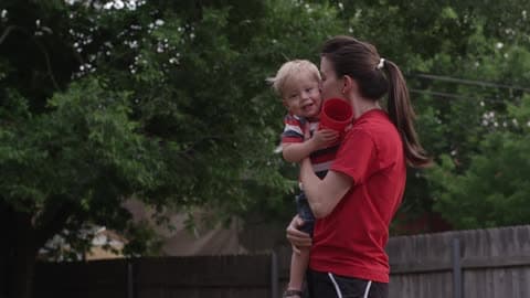 A Mother Holding And Kissing Her Toddler Boy
