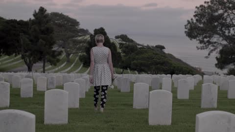 A Woman Walks Through A Cemetary