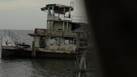 An Old, Dilapidated Structure Sits On The Ocean