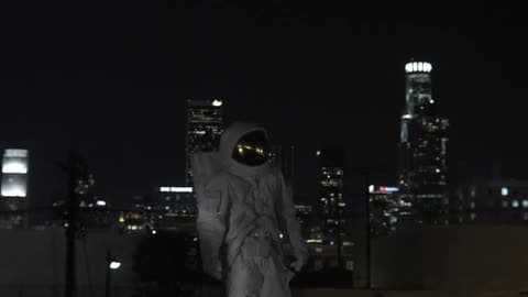 Man In Spacesuit Dancing At Night Outdoors In The City