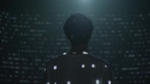 Projected Lights In Dashes And Dots Flash Over The Back Of A Person And All Around Him