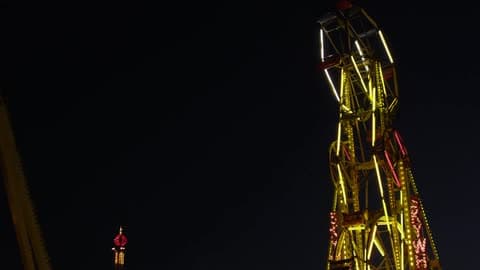 The Giant Wheel In An Amusement Park Rotates On A Dark Night
