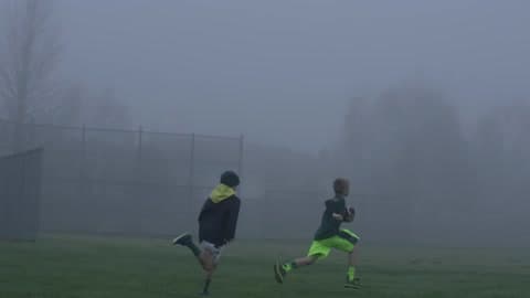 Three Boys Run Through A Foggy Park