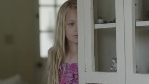 Young Girl Sadly Looking Around A Hutch Indoors